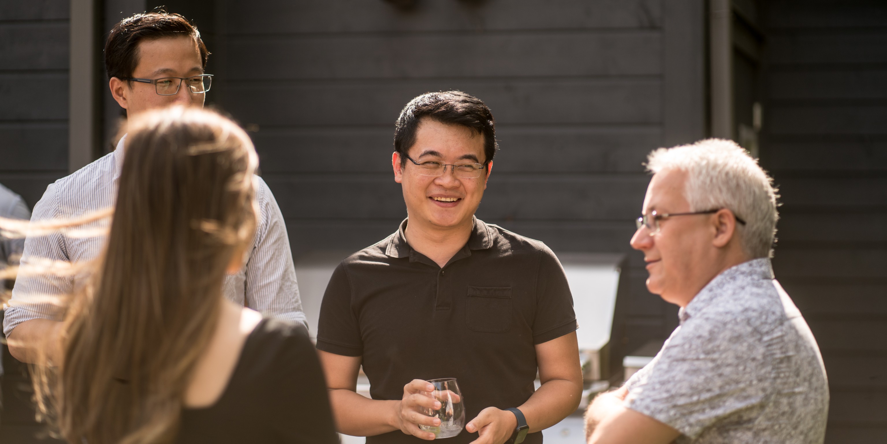 Small group of four people interacting and smiling